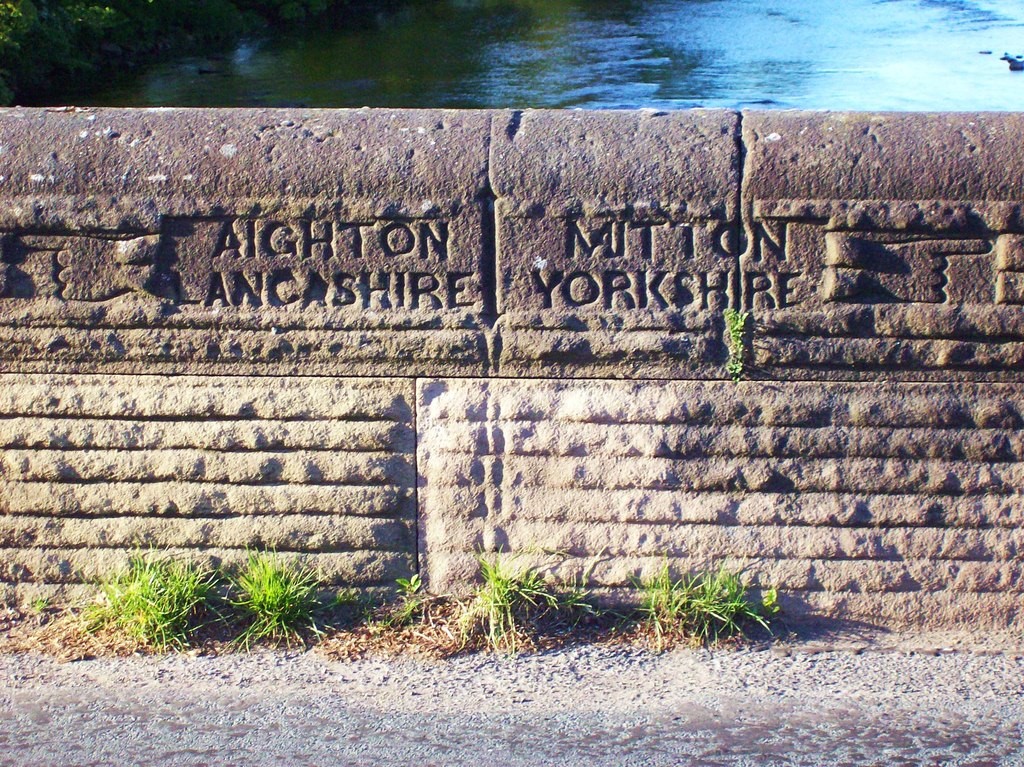 Canal path sign on wall pointing to Yorkshire in one direction and Lancashire in another